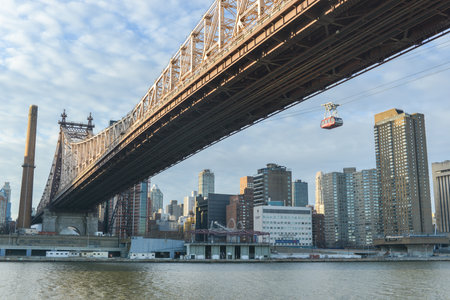 NEW YORK, NY - JANUARY 19, 2013: The famous Roosevelt Island cable tram car that connects Roosevelt Island to Manhattan alongside the Queensboro Bridge along Manhattan, New York City.のeditorial素材