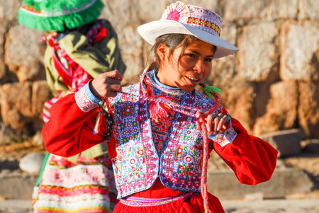 YANQUE, PERU - AUGUST 13, 2006: Peruvian girl in traditional garb, dancing in the morning light.