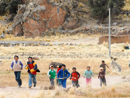 SACRED VALLEY OF THE INCAS, PERU - AUGUST 16, 2006: Children running along the road in Sacred Valley of the Incas.のeditorial素材
