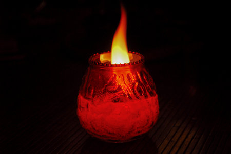 Flaming candle in a jar at night.の写真素材
