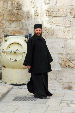 JERUSALEM, ISRAEL - JANUARY 20, 2007: Orthodox priest outside of the Holy Sepulchre Church. It is divided amongst six christian faiths.のeditorial素材