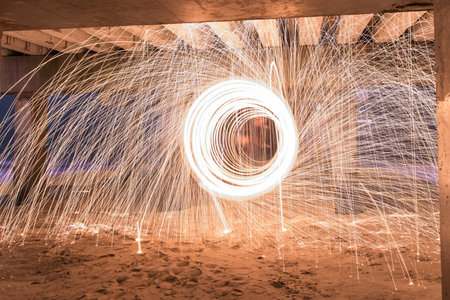 Showers of hot glowing sparks from spinning steel wool at Coney Island Beach, Brooklyn, New York.
