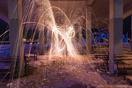Showers of hot glowing sparks from spinning steel wool at Coney Island Beach, Brooklyn, New York.の写真素材