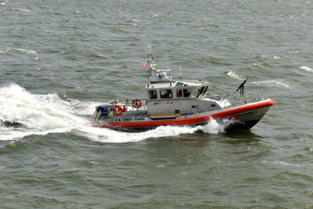 US Coast Guard Ship in the East River defending a Staten Island Ferry boat in New York.のeditorial素材
