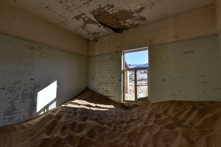 The abandoned ghost diamond town of Kolmanskop in Namibia, which is slowly being swallowed by the desert.の写真素材