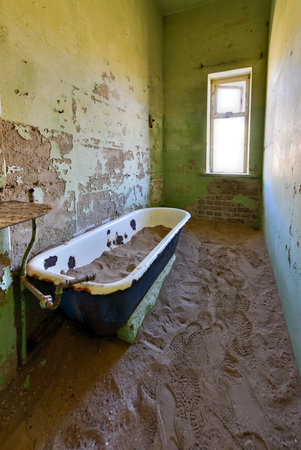 The abandoned ghost diamond town of Kolmanskop in Namibia, which is slowly being swallowed by the desert.の写真素材