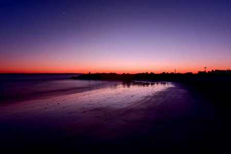 Long exposure of Coney Island Beach in Brooklyn, New York at sunset.