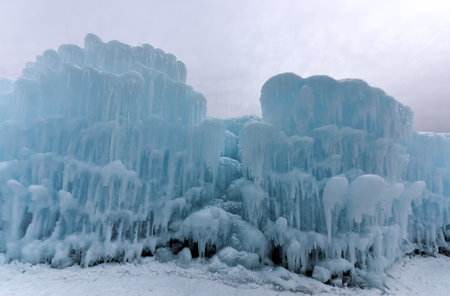 Translucent blue icicles in a frozen ice wall.の写真素材