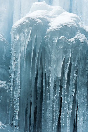 Translucent blue icicles in a frozen ice wall.