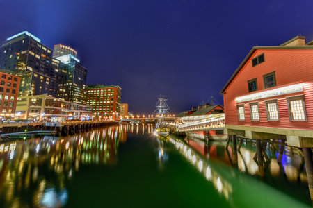 The Boston Tea Party Museum, in Boston Harbor in Massachusetts, USA with its mix of modern and historic architecture at night.のeditorial素材
