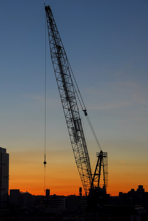 Construction against a background of a silhouette of New York City at sunset.の写真素材