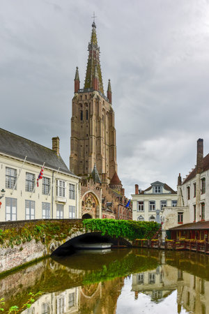 Canals of Bruges, Belgium with the Church of our Lady in the backgroundの写真素材