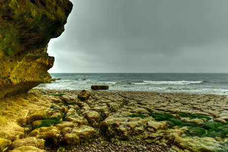Spectacular natural cliffs Aval of Etretat and beautiful famous coastline on a cloudy day in Normandy, France, Europe.の写真素材