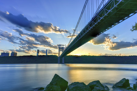 George Washington Bridge at sunset over the Hudson River from Manhattan.の写真素材