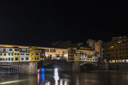 TheÂ Ponte VecchioÂ is aÂ medievalÂ stone closed-spandrelÂ segmentalÂ arch bridgeÂ over theÂ Arno River, inÂ Florence, Italy, noted for still having shops built along it, as was once common.の写真素材