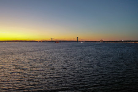 Aerial panoramic view of the Verrazano Bridge at sunset in New York City.