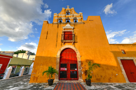 Church of Jesus in the colonial style, painted yellow in Campeche, Mexico with "entrance" on the door.のeditorial素材