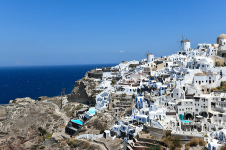 Charming view Oia village on Santorini island, Greece. Traditional famous blue dome church over the Caldera in Aegean sea. Traditional blue and white Cyclades architecture.の写真素材