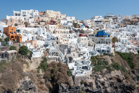 Charming view Oia village on Santorini island, Greece. Traditional famous blue dome church over the Caldera in Aegean sea. Traditional blue and white Cyclades architecture.の写真素材
