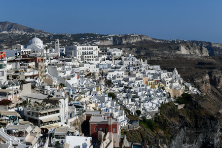 Charming view Fira village on Santorini island, Greece. Traditional famous blue dome church over the Caldera in Aegean sea. Traditional blue and white Cyclades architecture.の写真素材