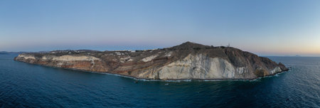 Aerial view of the Akrotiri Lighthouse at sunset in Santorini, Greece.