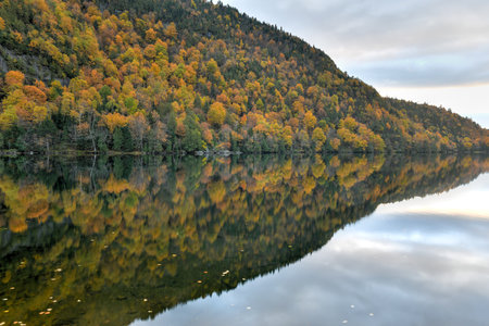 Peak fall foliage in Keene, New York by Cascade Lake at sunset.のeditorial素材