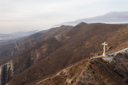 Gelendzhik, Krasnodar region, Russia, Orthodox worship cross on the hill of Caucasian mountains with chapel in foundation. Day time in winter.の写真素材