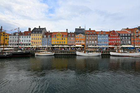 Copenhagen, Denmark - Jul 15, 2023: The Nyhavn (new harbour) waterfront with historic boats and coloured houses in the background.のeditorial素材