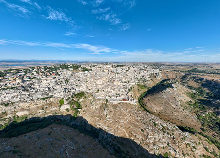 Aerial view of the ancient town of Matera (Sassi di Matera) in beautiful Basilicata, southern Italy. ancient cave houses carved into the tufa rock over the deep ravine, Gravina River.の写真素材