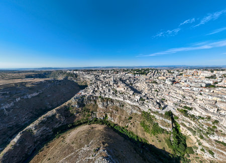Aerial view of the ancient town of Matera (Sassi di Matera) in beautiful Basilicata, southern Italy. ancient cave houses carved into the tufa rock over the deep ravine, Gravina River.の写真素材