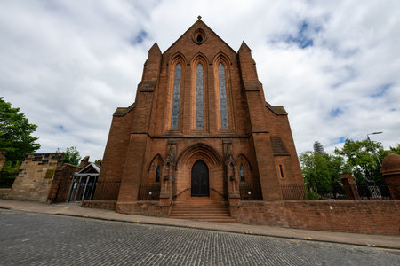The building of Barony Hall known also as the Barony Victorian Gothic Church on Castle Street in Glasgow behind treesの写真素材