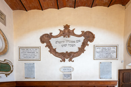 Pitigliano, Italy - Jul 13, 2025: The Pitigliano Synagogue features elegant chandeliers and archways. Its minimalist walls and checkered floor create a solemn atmosphereの写真素材