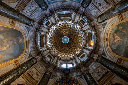 Siena, Italy - Jul 19, 2025: Upward view of the ornate coffered dome and marble columns inside medieval Siena Cathedral, a major Gothic landmark in Tuscany.の写真素材