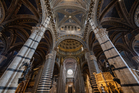 Siena, Italy - Jul 19, 2025: Siena Cathedral's interior features intricate Gothic black-and-white marble arches and a star-studded dome, capturing the city's medieval grandeur.の写真素材