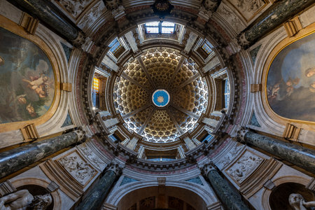 Siena, Italy - Jul 19, 2025: Upward view of the ornate coffered dome and marble columns inside Siena Cathedral, a major Gothic cathedral of medieval Tuscany.の写真素材