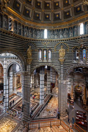 Siena, Italy - Jul 19, 2025: The Siena Cathedral's interior showcases Gothic architecture with striped marble columns and a star-studded dome, reflecting Italian craftsmanship. Siena, Italy.の写真素材