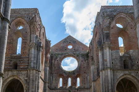 Interior ruins of the 13thâcentury Cistercian Abbazia di San Galgano near Chiusdino, showing Gothic stone arches and roofless brick nave.の写真素材