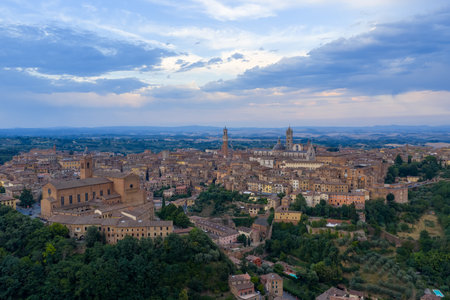 Aerial view of Siena, Italy, showcasing medieval red brick structures and narrow streets. Evening light accentuates the city's Tuscan landscapeの写真素材