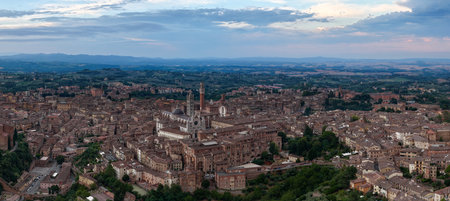 Panoramic aerial view of Siena's medieval architecture, dominated by the Gothic towers of Siena Cathedral and Palazzo Pubblico.の写真素材