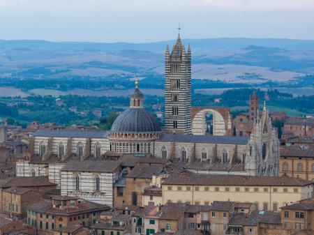 The Siena Cathedral, a masterpiece of Italian Romanesque-Gothic architecture, features black and white marble stripes, intricate facades, and a striking dome.の写真素材