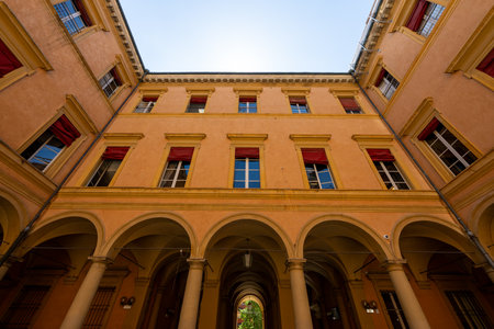 Bologna, Italy - Jul 23, 2025: Interior courtyard of Palazzo Ercolani in Bologna, showing arcaded portico, painted stucco facade, tall windows and summer sun overhead.の写真素材