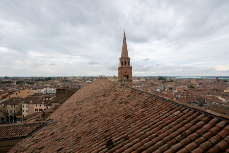 View along the terracotta-tiled roof toward the Renaissance bell tower of Basilica di SantâAndrea above the historic center of Mantua.の写真素材