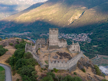 Aerial view of medieval Castello di Cly hilltop fortress above Saint-Denis in the Aosta Valley Alps at summer sunset.の写真素材