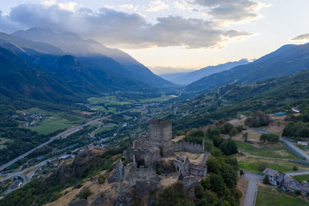 Aerial view of medieval Castello di Cly ruins overlooking the Aosta Valley and surrounding Alpine mountains at sunset near Saint-Denis.の写真素材