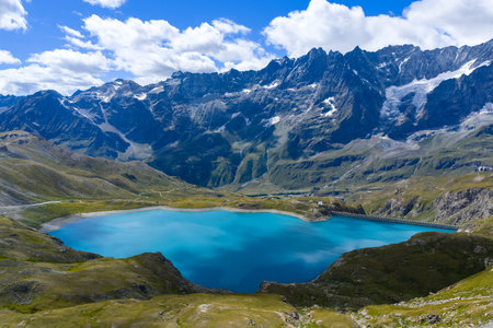 Turquoise waters of Lago Goillet reservoir beneath glaciated Alpine peaks near Valtournenche in the Aosta Valley, northwestern Italy.の写真素材