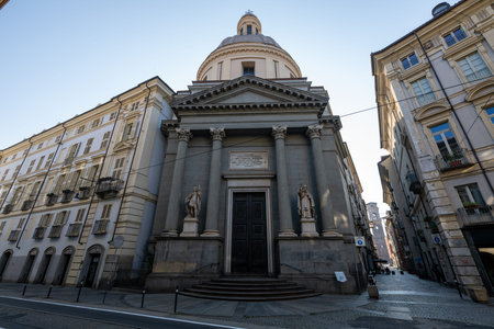 Neoclassical Basilica of Saints Maurice and Lazarus in Turin, featuring columned portico, statues of saints and towering dome on a quiet street.の写真素材