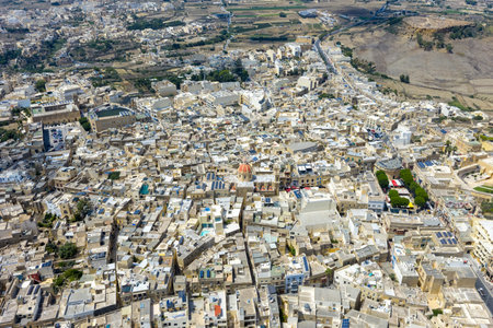 Aerial view of Victoria (Rabat), Gozo, showing dense limestone buildings, narrow streets, and the Citadel hilltop fortress dominating the town center.の写真素材