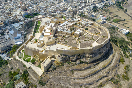Aerial view of the Cittadella in Victoria (Rabat), Gozo, showing the walled hilltop fortress and surrounding town blocks under bright daylight.の写真素材