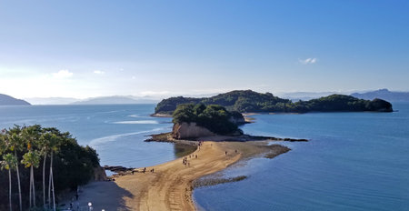 Indistinct tourists enjoying the scenery at Angel Road, a scenic area in Kagawa Prefecture, Japan, where the road disappears at high tide. -08の写真素材