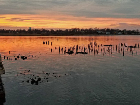 Colorful dramatic sunset at Keyport Harbor, New Jersey, with the sun setting behind some stratus...